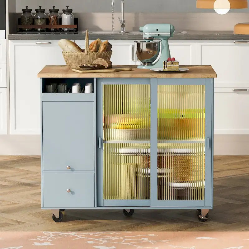 Îlot de cuisine avec surface à rabat, éclairage LED, portes en verre cannelé, étagère réglable, deux tiroirs et roulettes.