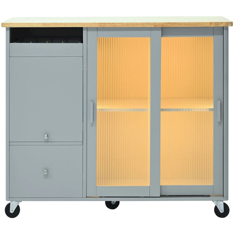 Îlot de cuisine avec surface à rabat, éclairage LED, portes en verre cannelé, étagère réglable, deux tiroirs et roulettes.