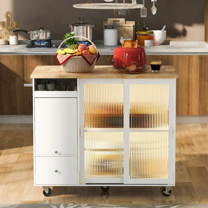 Îlot de cuisine avec surface à rabat, éclairage LED, portes en verre cannelé, étagère réglable, deux tiroirs et roulettes.