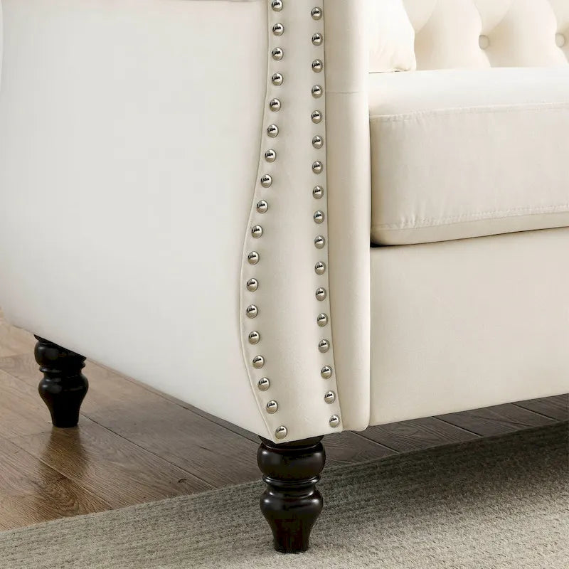 Canapé Chesterfield 3 places en velours beige, accoudoirs roulés, garniture cloutée