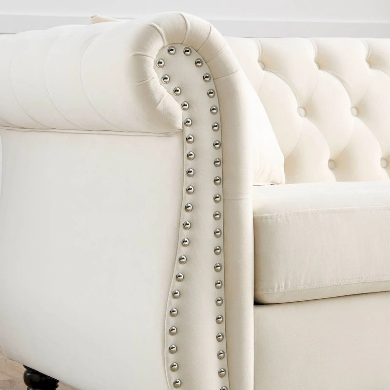 Canapé Chesterfield 3 places en velours beige, accoudoirs roulés, garniture cloutée